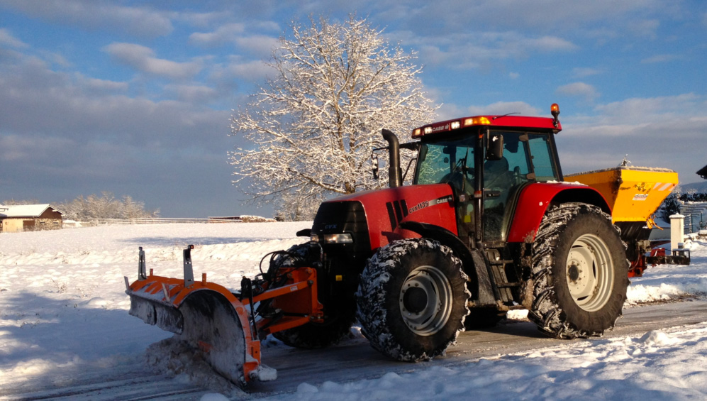 Tracteur de déneigement devant une route enneigée